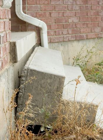 sinking outdoor concrete steps showing cracking and soil washout in Arlington