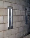 an inside view of foundation wall anchors installed along a basement wall to brace and repair the structure in Corinth