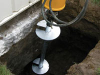 Installing a helical pier system in the earth around a foundation in Cordova